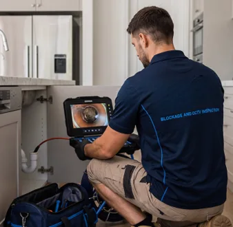 Plumber clearing a blocked toilet in a Petersham bathroom